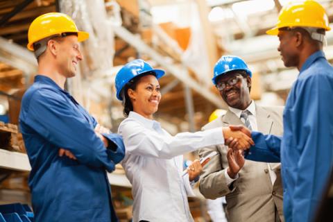 warehouse manager shaking hands with warehouse worker